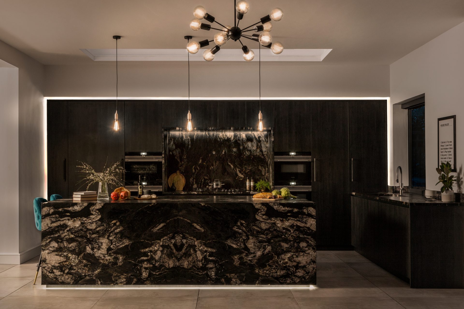 Extreme black boutique kitchen with accent lighting at night.