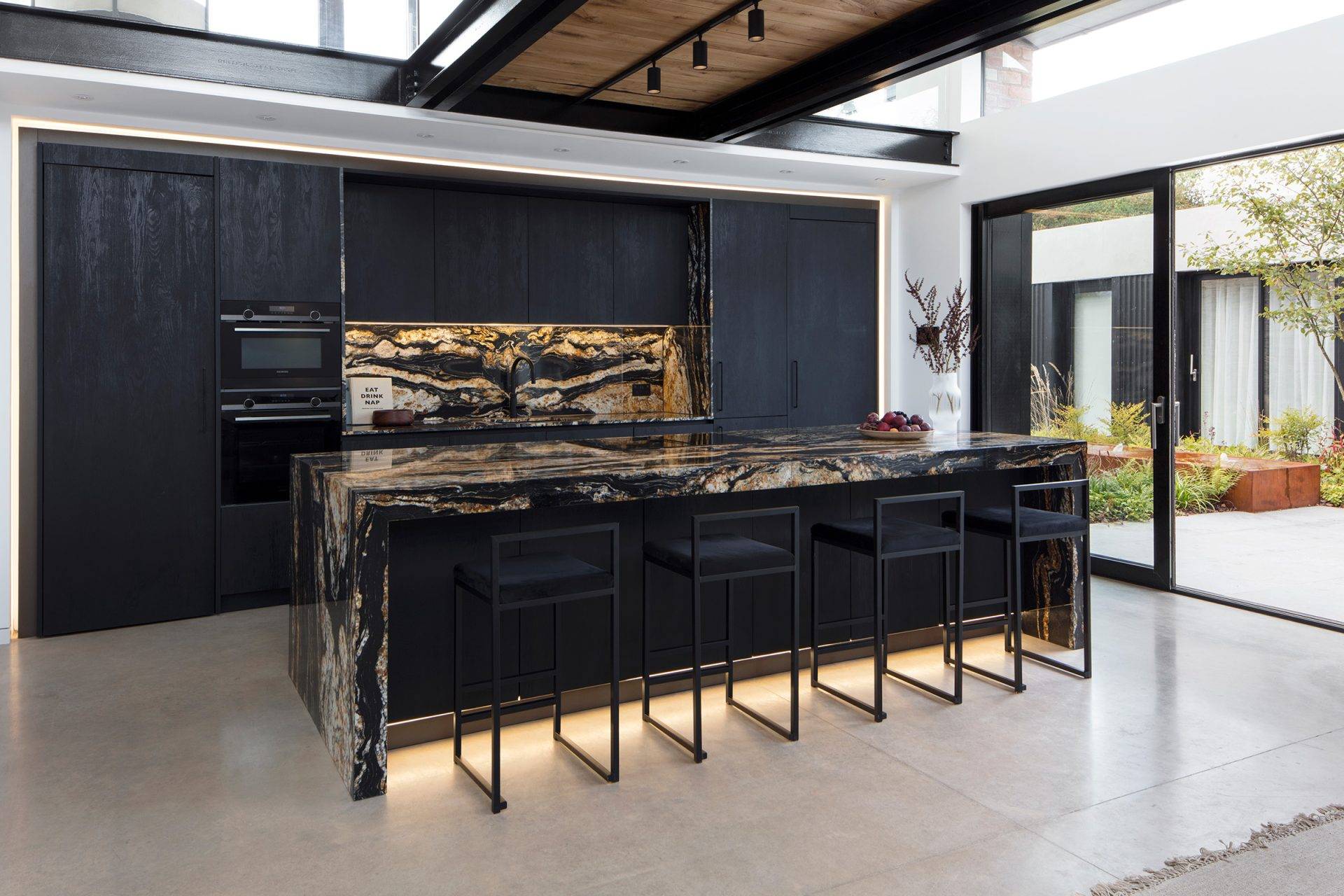 dark black kitchen with statement black and gold granite
