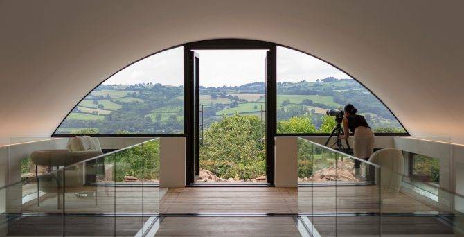 architectural home with curved roof and countryside views