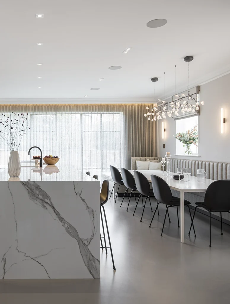 modern kitchen with marble island and built in banquette seating with dining table