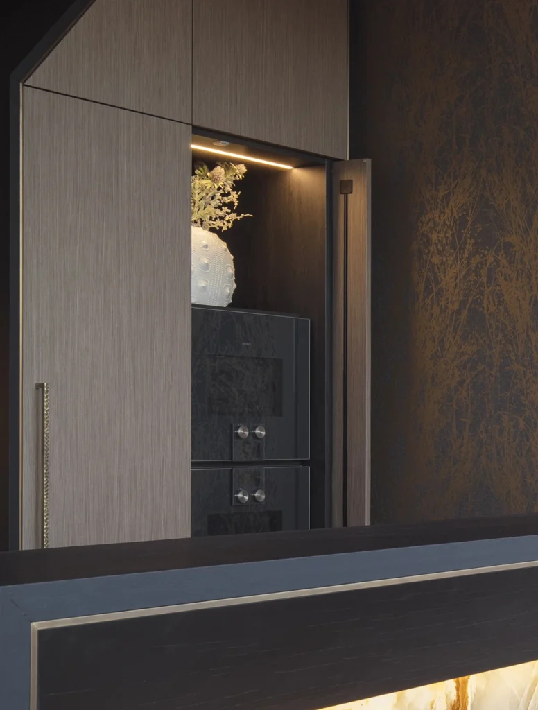 sleek timber kitchen cabinets with Gaggenau ovens hidden behind pocket door