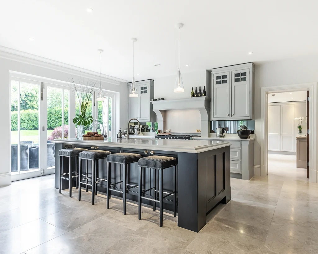 Traditional kitchen with dark blue island with marble worktops and breakfast bar seating